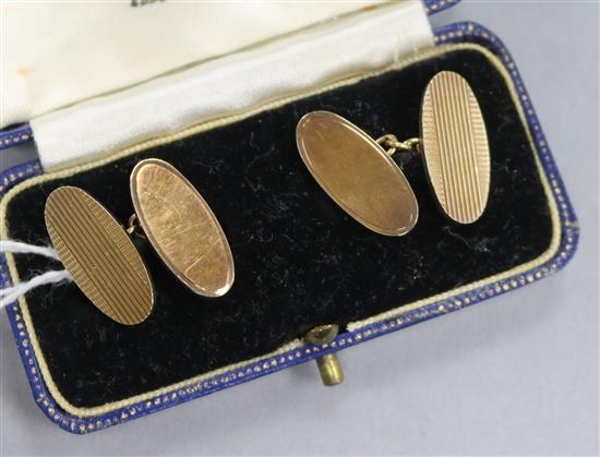 A pair of gold and silver engine turned oval disc cufflinks.